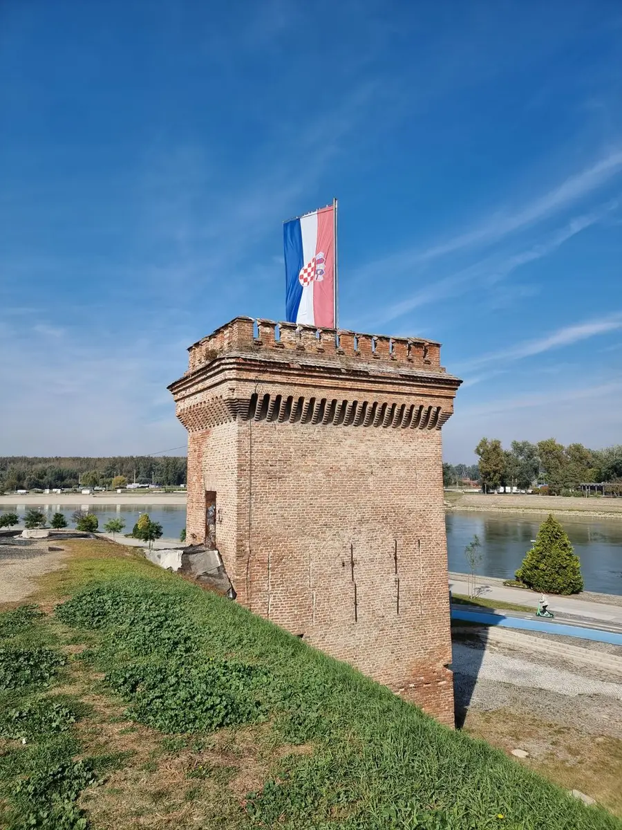 Kula od opeke s hrvatskom zastavom iznad Drave