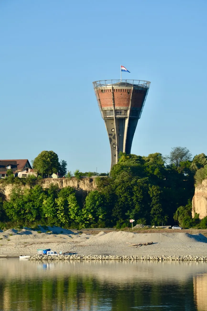 Vukovarski vodotoranj s hrvatskom zastavom iznad obale Dunava